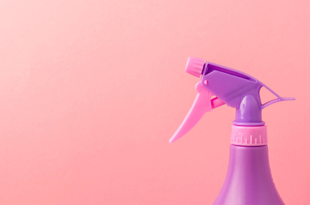 ugello spray su una bottiglia / ugello spray viola su una bottiglia su uno sfondo rosa. Copia spazio. - Foto, immagini