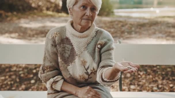 Старая уязвимая потерянная или бездомная женщина получает монеты. Концепция слабоумия и психические проблемы  - Кадры, видео