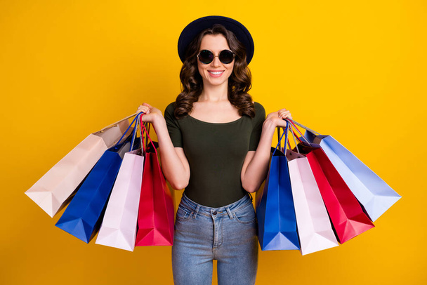 Portrait of her she nice attractive lovely fashionable pretty cheerful wavy-haired girl carrying new things bargain isolated on bright vivid shine vibrant yellow color background - Foto, Bild