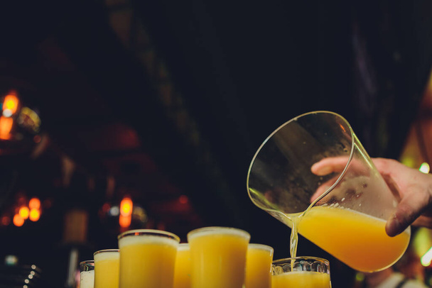 Sklenice pomerančového koktejlu zdobená citrónem na barovém pultu. - Fotografie, Obrázek