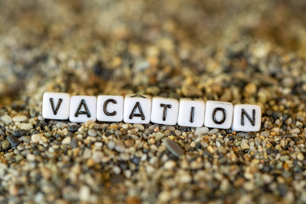 Текст відпустки з назвою міста призначення відпустки в натюрморті листів, викладених на берегових піщаних каменях
 - Фото, зображення