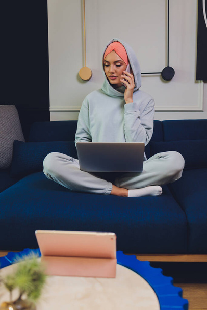 Beautiful Muslim middle-aged woman with laptop at home. - Fotó, kép