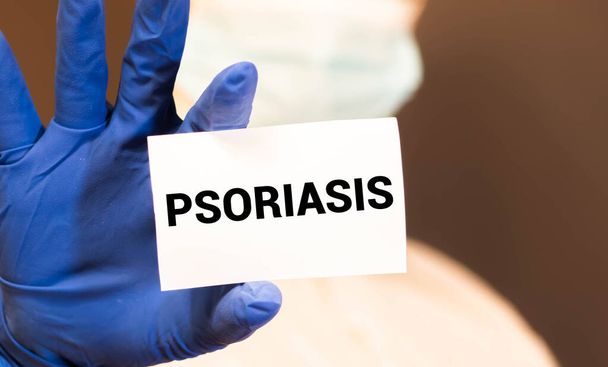 Man showing paper with PSORIASIS text, medical concept - Фото, изображение