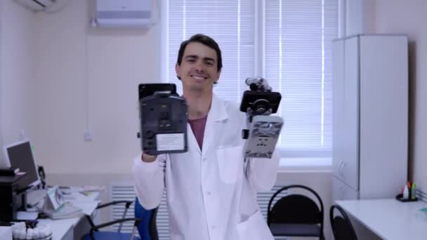 Felice medico in abito bianco danza allegramente in un laboratorio di scienze mediche - Filmati, video