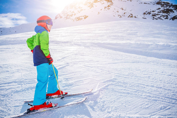 Cute skier boy in a winter ski resort. - Фото, изображение