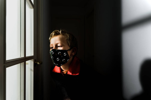 Ребенок в жуткой маске на лице в испуганном костюме на Хэллоуин. - Фото, изображение