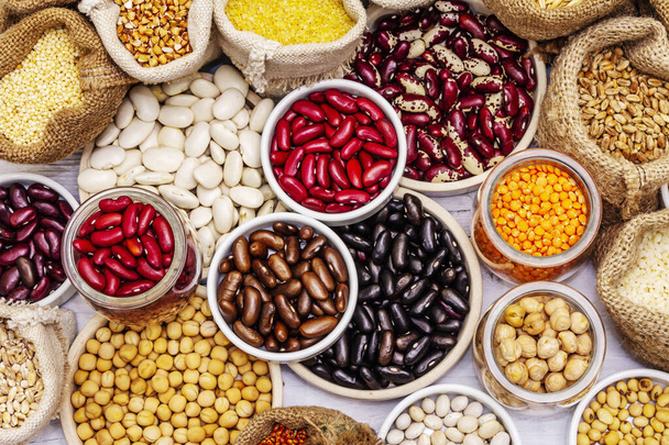 Vari tipi assortiti di fagioli e cereali. Set di fonti indispensabili di proteine per uno stile di vita sano. Bianco tavole di legno sfondo - Foto, immagini