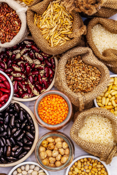 Sortidas diferentes tipos de grãos de feijão e cereais. Conjunto de fontes indispensáveis de proteína para um estilo de vida saudável. Branco pranchas de madeira fundo - Foto, Imagem