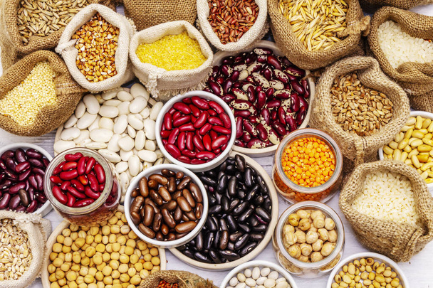 豆や穀物の異なる種類を割り当てます。健康な生活のためのタンパク質の不可欠な源のセット。白木板の背景 - 写真・画像
