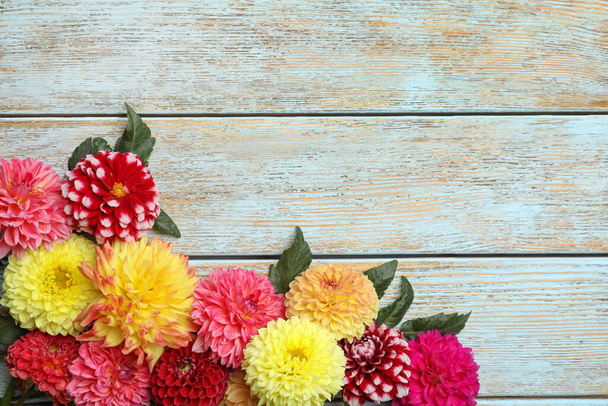 Beautiful dahlia flowers on wooden background, flat lay. Space for text - Φωτογραφία, εικόνα