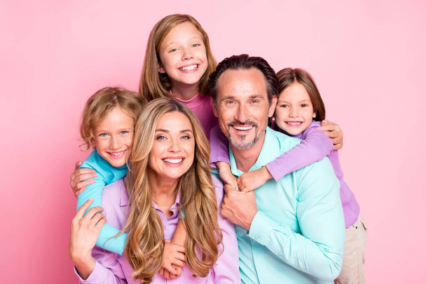 Photo of positive idyllic big family enjoy spend weekend together daddy piggyback younger daughter mommy hug her siblings offspring isolated over pastel color background - Zdjęcie, obraz