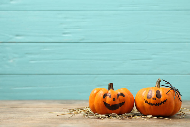 Pumpkins with scary faces on light blue wooden background, space for text. Halloween decor - Zdjęcie, obraz