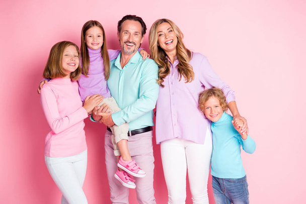 Zdjęcie pozytywne marzenie duża rodzina cieszyć się razem spędzić weekend tata trzymać młodszy dziewczyna mama trzymać ręka rodzeństwo chłopiec nosić casual styl ubrania izolowane ponad różowy kolor tła - Zdjęcie, obraz