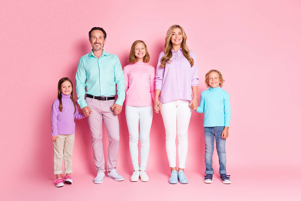 Full length photo of dream idyllic family portrait mother father and preteen small kids younger older siblings hold hand enjoy togetherness isolated over pink color background - Φωτογραφία, εικόνα