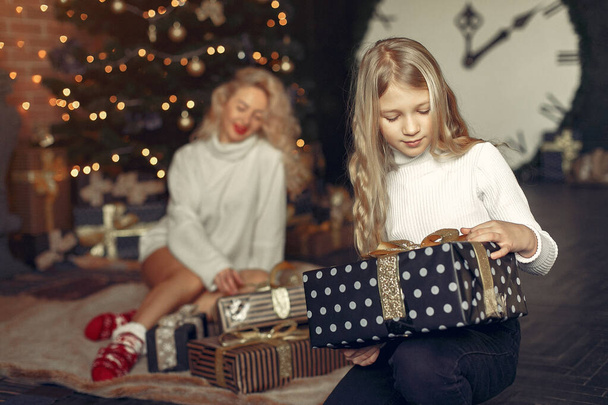 Mother with cute daughter at home near christmas tree - Foto, Imagem