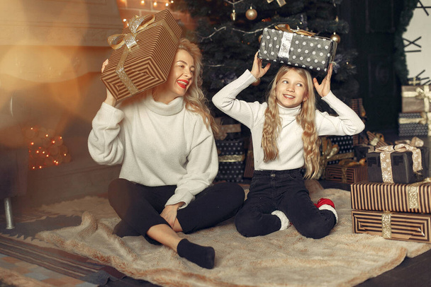 Mother with cute daughter at home near christmas tree - Photo, Image