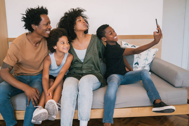 Portrait of African American family taking a selfie together with mobile phone at home. Family and lifestyle concept. - Foto, imagen