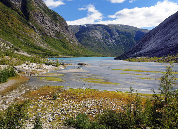 View To Lake Nigardsbrevatnet At The Glacier Nigardsbreen In Jostedalsbreen National Park On A Sunny Summer Day With A Clear Blue Sky And A Few Clouds - 写真・画像