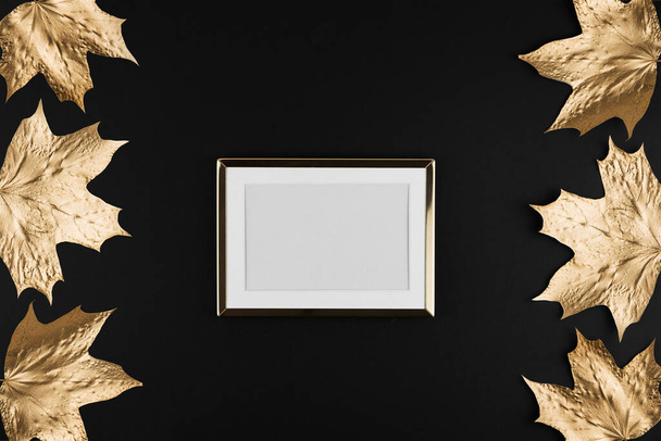 Autumn composition. Frame made of autumn golden maple leaves on black background. Flat lay, top view, copy space - 写真・画像