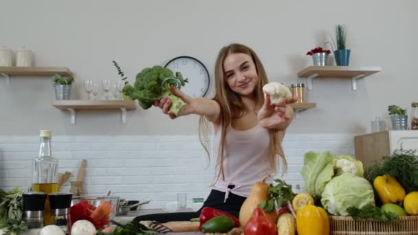 Mädchen empfiehlt, rohe pflanzliche Lebensmittel zu essen. Zeigt Brokkoli und Blumenkohl. Gewichtsverlust, Ernährung - Filmmaterial, Video