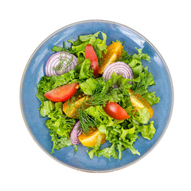 Dania z warzyw, menu fitness. Niebieski talerz z sałatką na białym tle. Studio zdjęcie - Zdjęcie, obraz