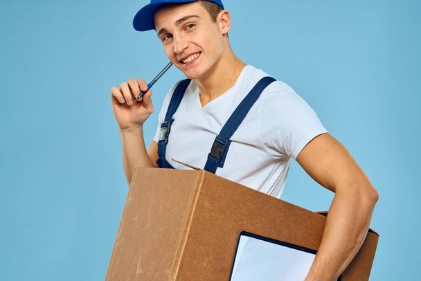 Uomo lavoratore con scatola di cartone consegna caricatore stile di vita sfondo blu - Foto, immagini