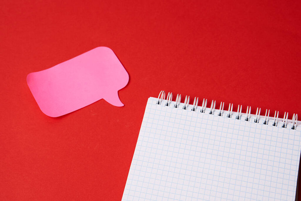 Notepad with pink sticky note on red background top view Copy Space - Foto, immagini