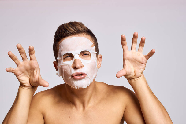 man with cleansing mask on face against black dots on isolated background cropped view - Foto, Imagen