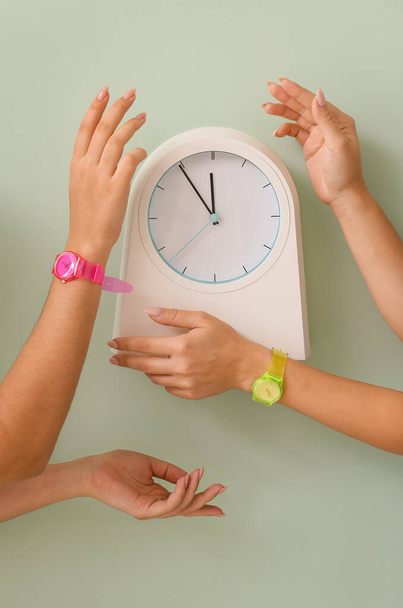 Agujas femeninas con relojes y reloj sobre fondo de color - Foto, imagen