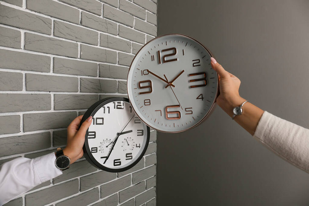 Hands with clocks on grey background - Foto, imagen