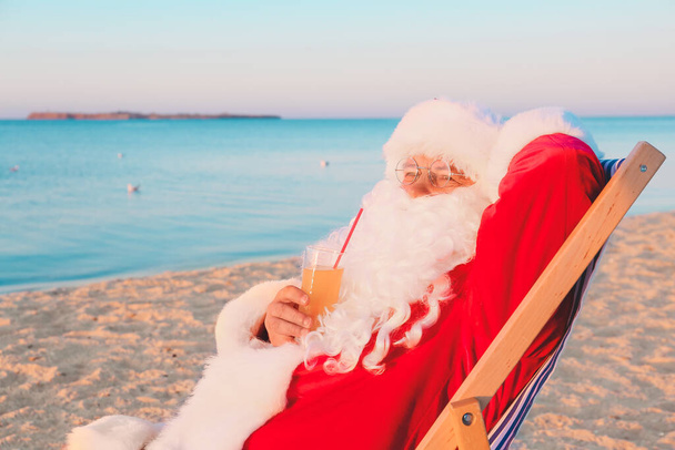 Święty Mikołaj odpoczywający w kurorcie morskim. Święta Bożego Narodzenia - Zdjęcie, obraz