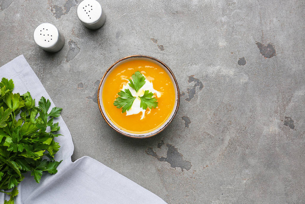 Tasty pumpkin cream soup in bowl on grunge background - Photo, Image