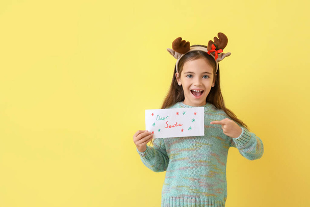 Little girl with letter to Santa on color background - Фото, зображення