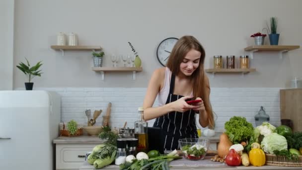Mujer bloguera preparando comida, tomando fotos en el teléfono para sus cuentas sociales o historias de video - Metraje, vídeo