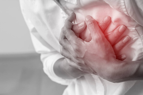 Человек, сжимающий грудь от острой боли - симптомы сердечного приступа - Здоровье и медицинская концепция. - Фото, изображение