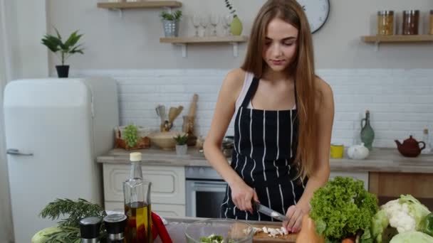 Veganerin kocht Salat mit rohem Gemüse, während sie auf dem Handy nach Online-Rezept sucht - Filmmaterial, Video