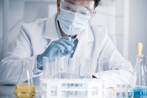 Azjatycki naukowiec pracujący w laboratorium. Koncepcja rozwoju szczepionek. - Zdjęcie, obraz