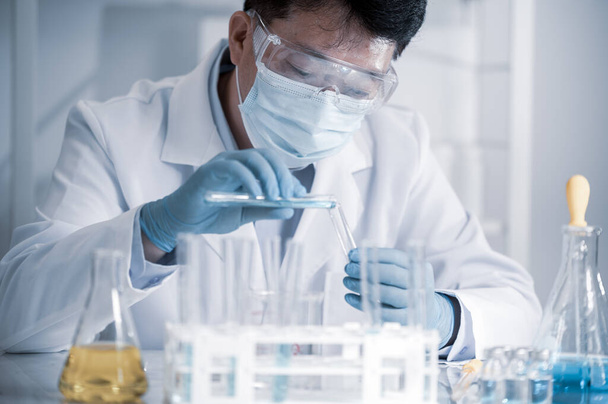 Científico asiático trabajando en un laboratorio. Concepto de desarrollo de vacunas. - Foto, imagen