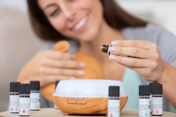 woman dripping essential oils into a diffuser - Foto, Imagen