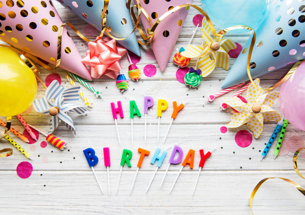 Text Happy Birthday by candle letter with birthday asseccores, candle and confetti on pwhite wood background - 写真・画像