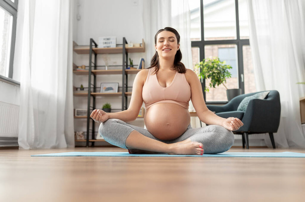 happy smiling pregnant woman meditating at home - Фото, изображение