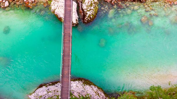 Vista aérea del río azul turquesa Soca (Isonzo) y puente de madera cerca de Bovec en los Alpes Julianos en Eslovenia - Foto, imagen