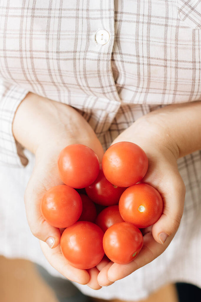 Elinde taze ve olgun domatesler tutan bir kadın. - Fotoğraf, Görsel