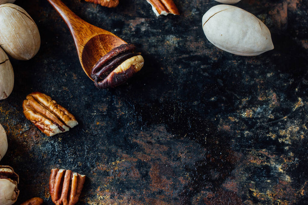 Pecan nut and wooden spoon on rustic table - Foto, imagen