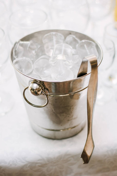 Cold ice in a bucket. Ice Bucket with tranparent cubes of ice. - Photo, Image