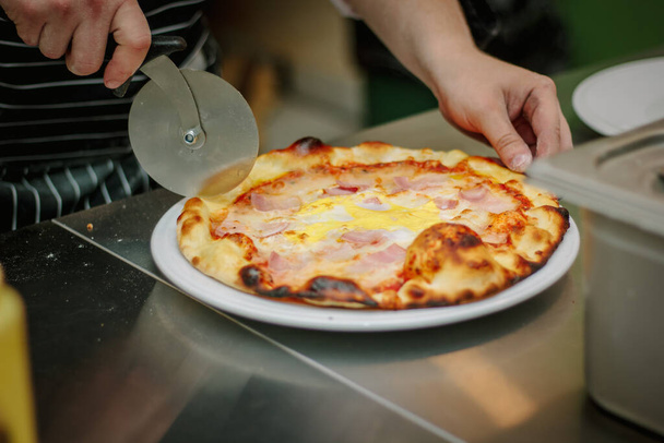 Chef corte de pizza com a faca de pizza redonda - Foto, Imagem
