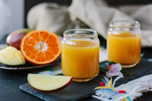 Mango ja appelsiini detox juoda yli musta liuskekivi aluksella - Valokuva, kuva