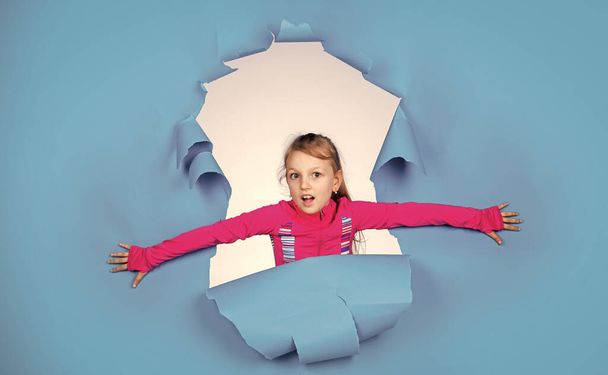 Following her personal style. kid with cheerful emotions. female hairdresser salon. beauty and fashion. happy child has casual look. trendy kid has happy childhood. small girl on blue background - Foto, afbeelding