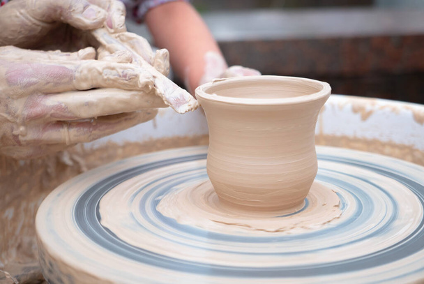 Potter forming a ceramic jug on pottery wheel. - Photo, Image