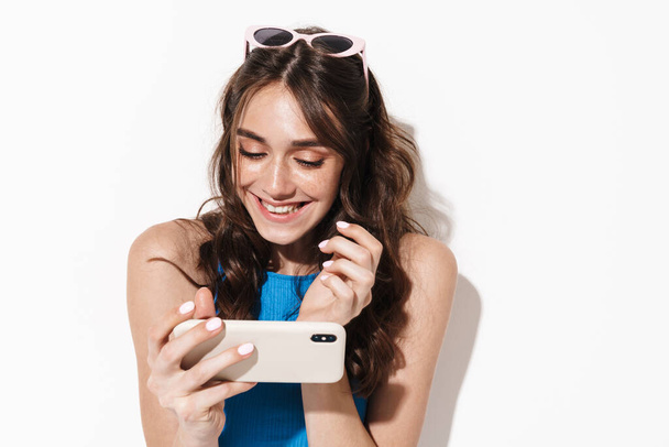 Image of happy beautiful woman using cellphone and smiling isolated over white background - Φωτογραφία, εικόνα